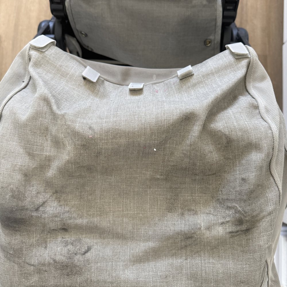 Stroller basket before cleaning, heavily soiled